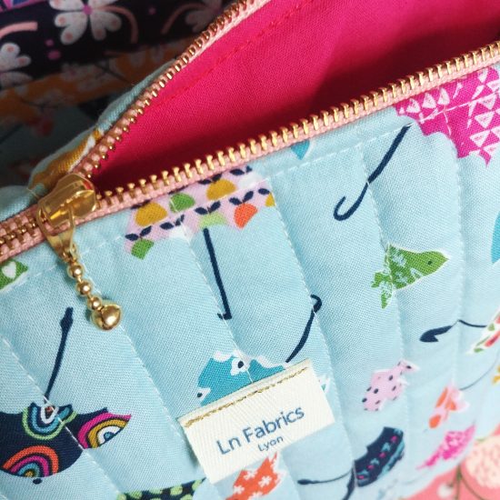 Trousse de toilette pour maman pour bébé en tissu matelassé, imprimé parapluies de chez Dashwood studio