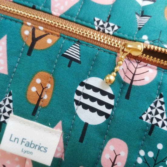 Détail chic et raffiné le zip doré de la trousse matelassée en tissu imprimé Dashwood Studio geo forest