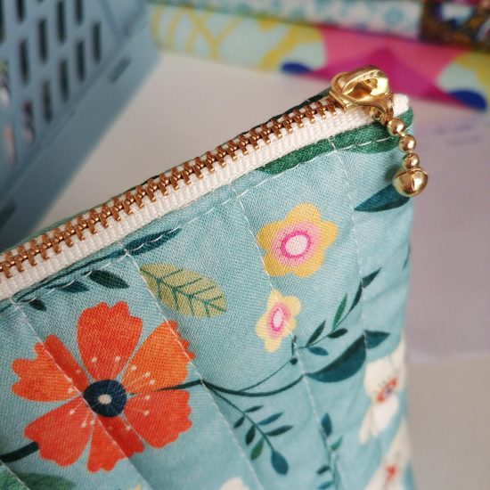 Détail chic et raffiné le zip de la trousse en tissu matelassé coton imprimé bleu fleurs oranges et blanches Dashwood Studio Hedgerow
