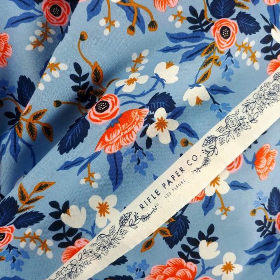 coton imprimé Rifle Paper Co Les Fleurs motif fleuri joyeux coloré orange bleu vif marine et blanc sur un fond bleu lumineux