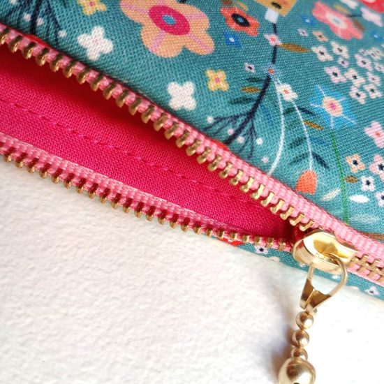 pochette fabrication française en coton imprimé Dashwood Studio imprimé fleuri et fond bleu paon détail chic le zip doré ruban rose doublure coton rose fuschia