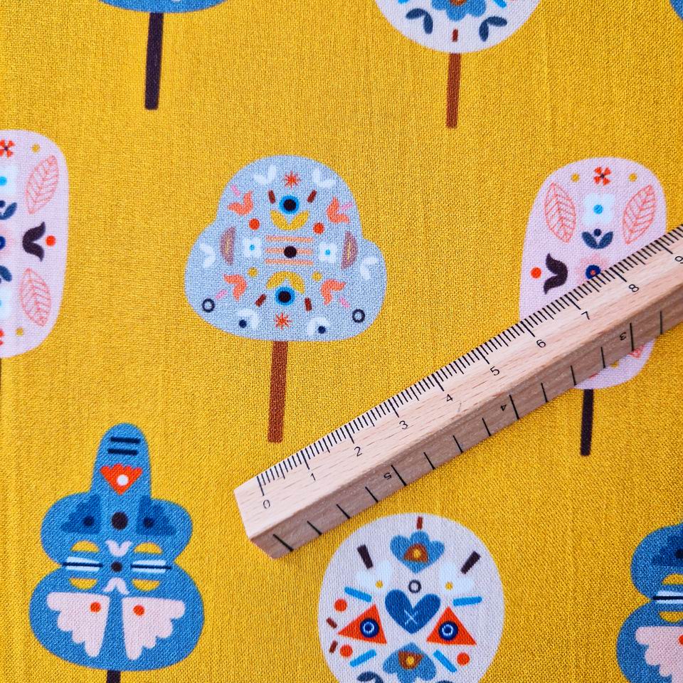 tissu dashwood studio imprimé arbres couleurs douces et pastels sur un fond peps ocre jaune intense et lumineux parfait pour la couture créative