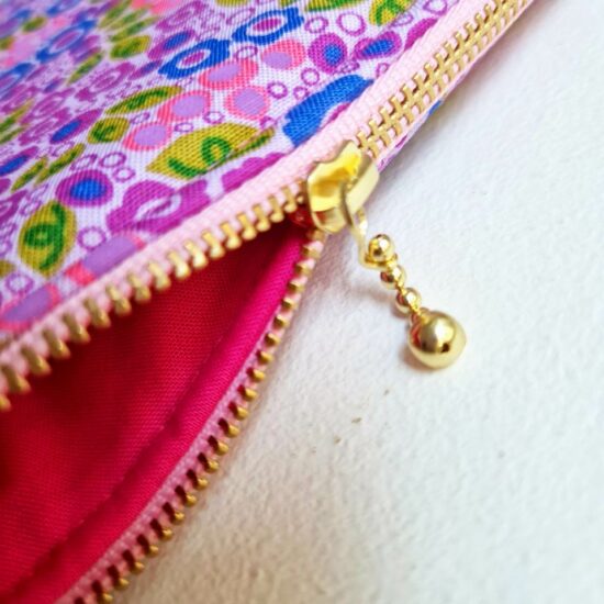 Doublure en coton rose fuschia pour cette pochette trousse de maquillage molletonnée jolie finition zip curseur billes dorées ruban rose pale