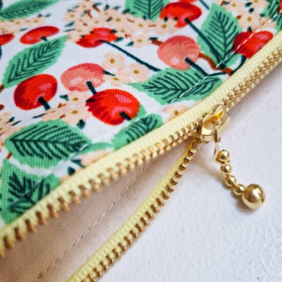 Doublure en coton écru pour cette pochette trousse de maquillage molletonnée jolie finition zip curseur billes dorées ruban rose pale