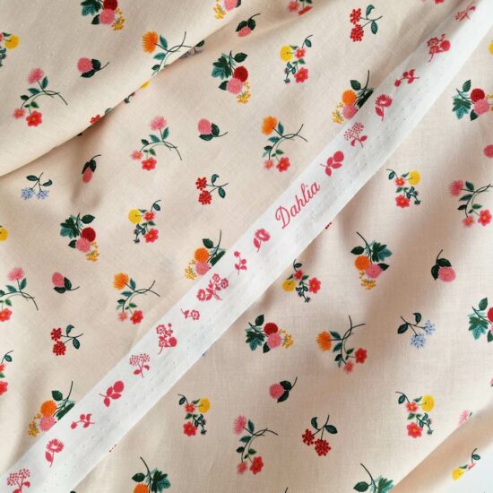 Imprimé Dahlia mini fleurs rifle paper co un semis floral doux et délicat orange, rose thé, rouge, jaune d'or sur un fond nude beige rosé