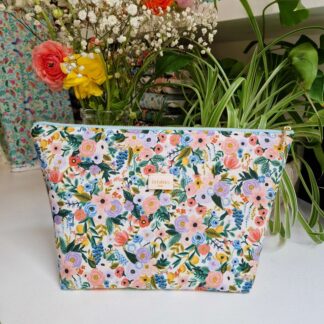 Trousse molletonnée en tissu imprimé fleuri Rifle Paper Co couleurs pastels délicates sur un fond crème