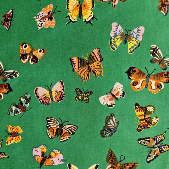 Tissu Nathalie Lété coton imprimé motif papillons fond vert papillons oranges, dorés, roses