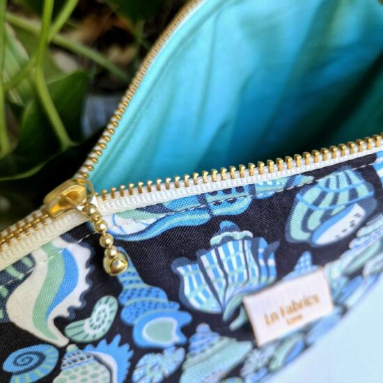 Jolie finition pour cette trousse de voyage ou de toilette doublure en coton bleu aqua joli zip curseur billes dorées ruban zip blanc détails et finitions soignées fabrication française