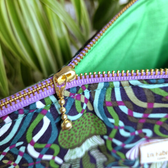 Jolie finition pour cette trousse de voyage ou de toilette doublure en coton vert perroquet joli zip curseur billes dorées ruban zip violet détails et finitions soignées fabrication française