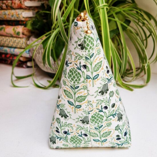 Joli volume pour cette trousse en tissu rifle paper co molletonnée imprimé végétal Dahlia avec ces fleurs d'artichauts vert sur fond blanc ponctués d'or métallisé