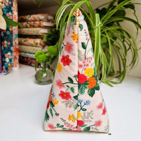 Joli volume pour cette trousse en tissu rifle paper co molletonnée imprimé Dahlia avec ces fleurs joyeuses et multicolores sur fond crème
