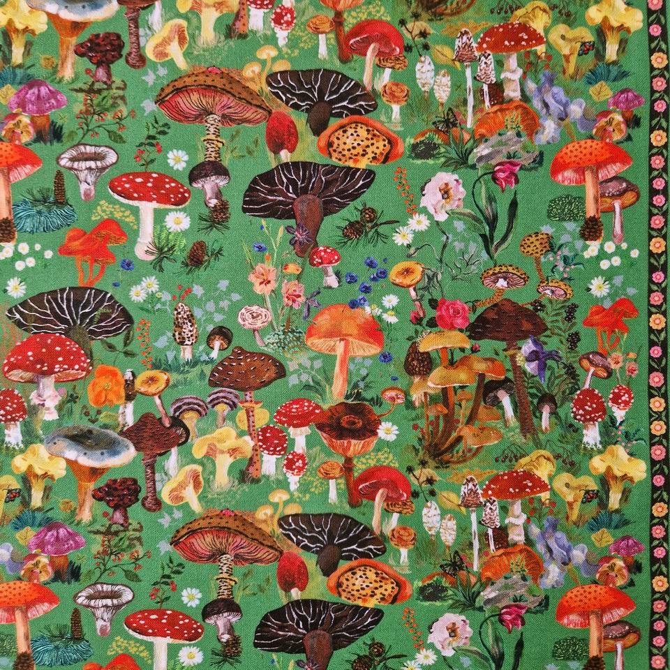 Tissu imprimé champignons magiques de Nathalie Lété pour Free Spirit une multitude de champignons colorés sur un fond vert mousse