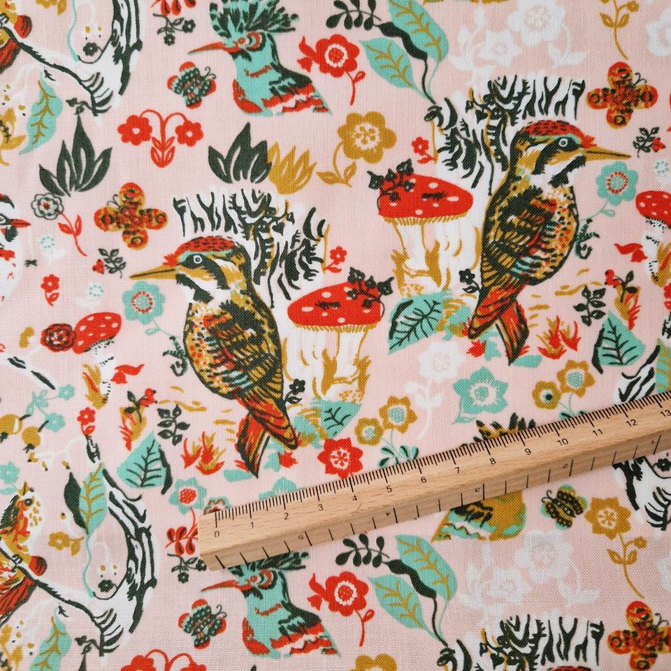 Motif oiseau pour ce tissu en coton imprimé Nathalie Lété oiseaux dessinésrouge or sur un fond rose nude avec des champignons rouges et du feuillage vert d'eau