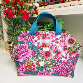 Sac à projets clap clap molletonné en tissu Odile Bailloeul coton imprimé fleurs sous la pergola, des grosses fleurs roses et blanches qui laissent entrevoir le ciel bleu
