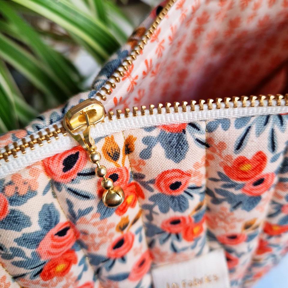 Petit bijou de trousse fabriqué en France trousse de voyage ou sac à projets matelassée avec du fil doré doublure imprimé mini motifs géométriques zip curseur chic triple billes dorées ruban blanc