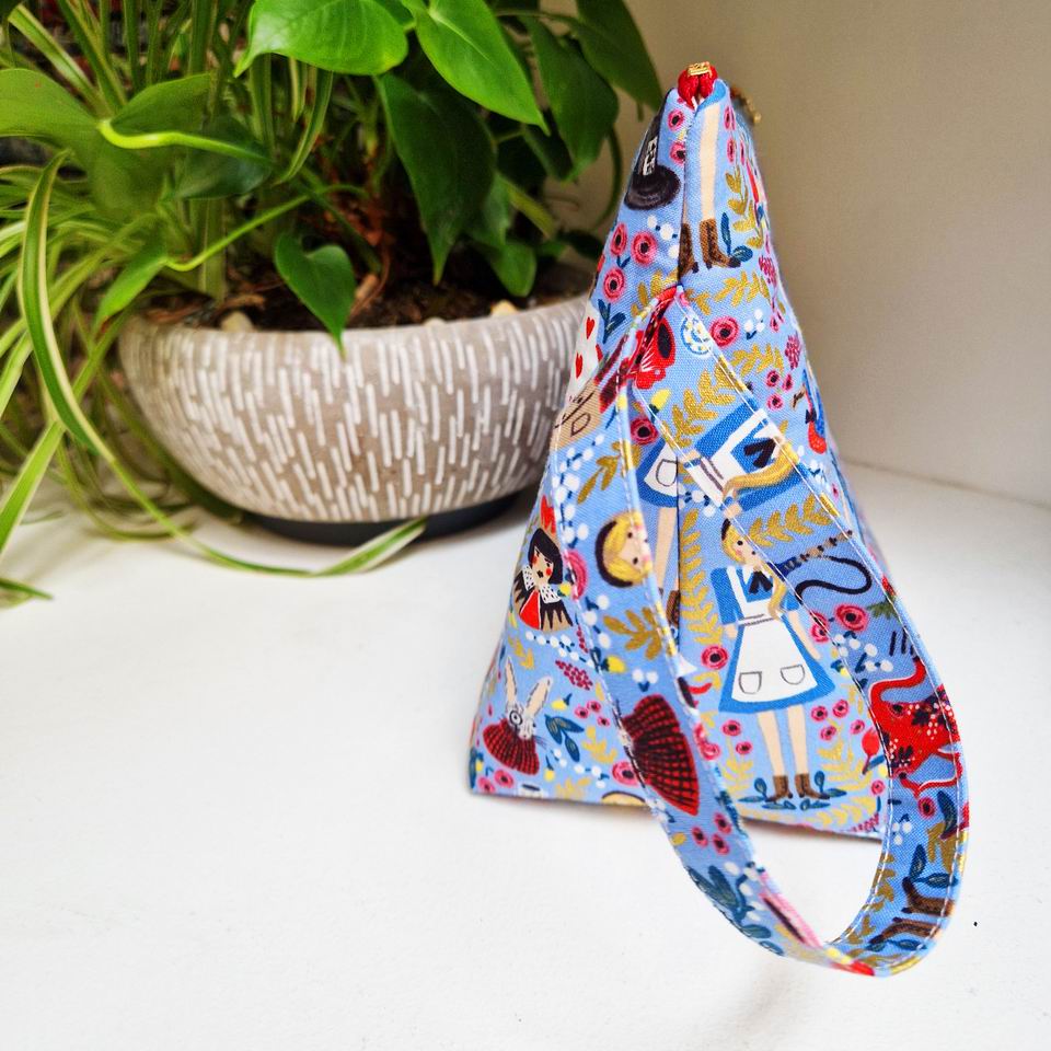 Joli volume pour cette trousse grand modèle avec poignée et poche intérieure imprimé Alice bleu lavande Rifle Paper Co