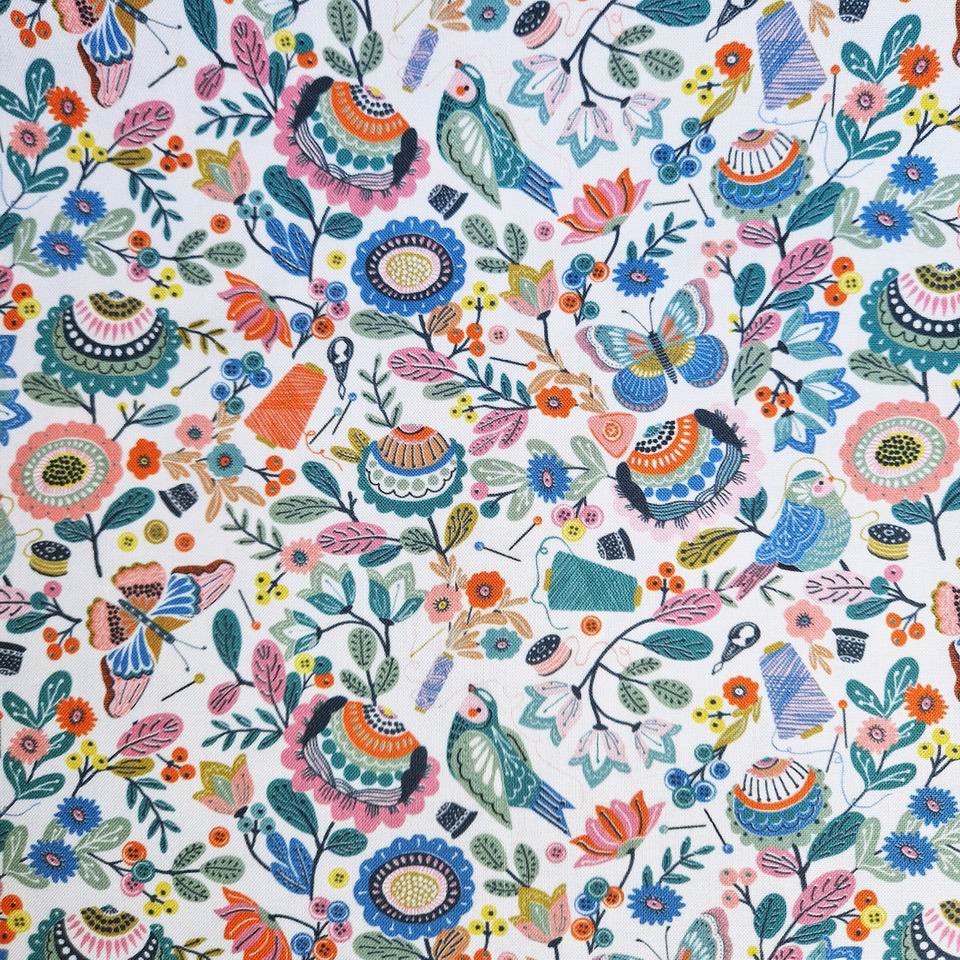 Tissu imprimé fleurs papillons oiseaux et thème de la couture avec des oiseaux clairs couleurs pastels sur fond blanc bobines de fil
