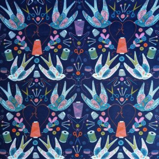 Tissu imprimé thème de la couture avec des hirondelles blanches sur fond bleu marine bobines de fil orange et vertes