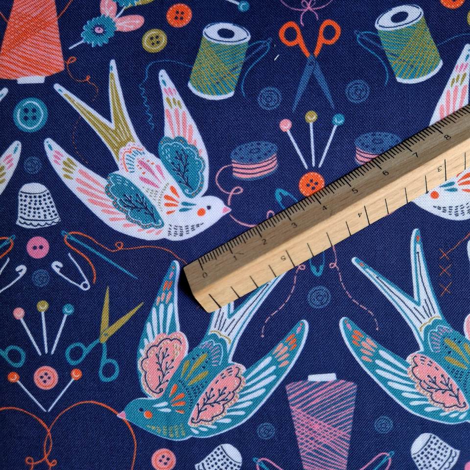 Tissu coton imprimé motif oiseau hirondelle tient dans son bec du fil thème de la couture hirondelle blanche sur fond bleu marine