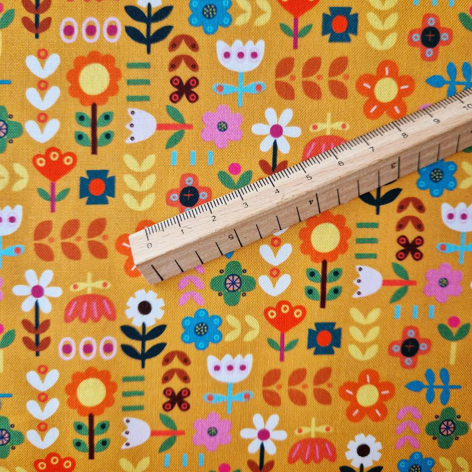 Tissu coton oeko tex motif floral couleurs chaudes et automnales style scandinave fond jaune doré fleurs blanches rose bleu rose