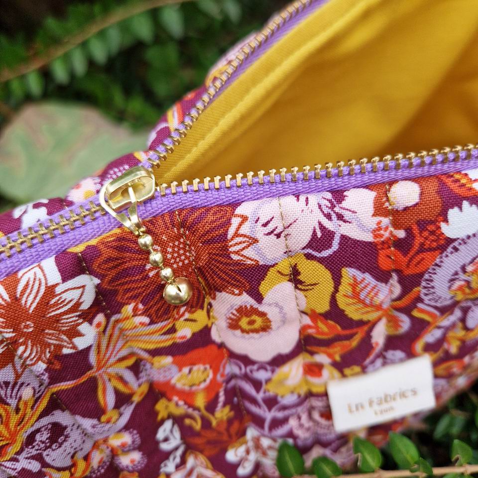 Trousse matelassée tissu imprimé floral Nathalie Lété sur fond prune doublure en coton jaune doré
